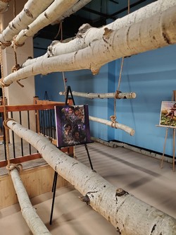 photo of aspen logs hung in gallery